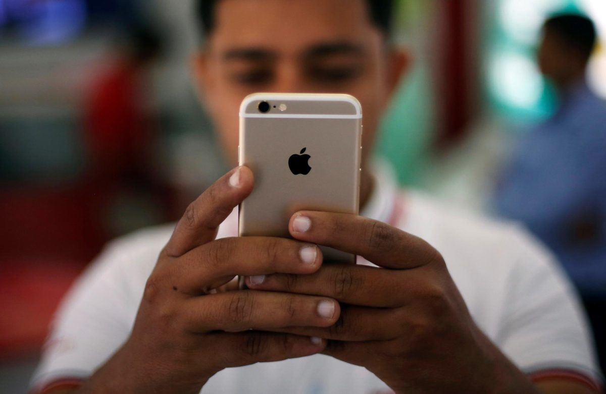 A salesman checks a customer's iPhone at a mobile phone store in New Delhi, India, July 27, 2016. REUTERS/Adnan Abidi